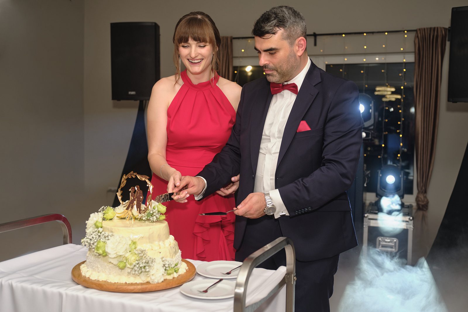 Nowożeńcy wspólnie kroją weselny tort.