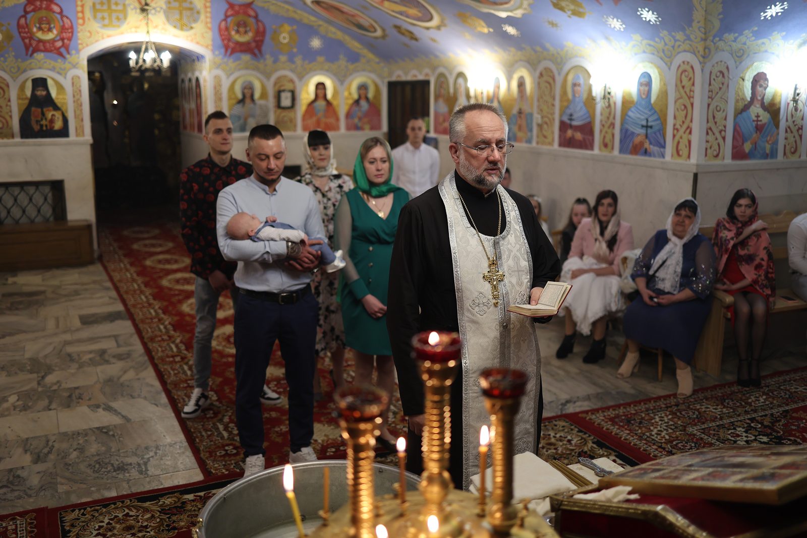 Priest performing an infant baptism in an Orthodox church