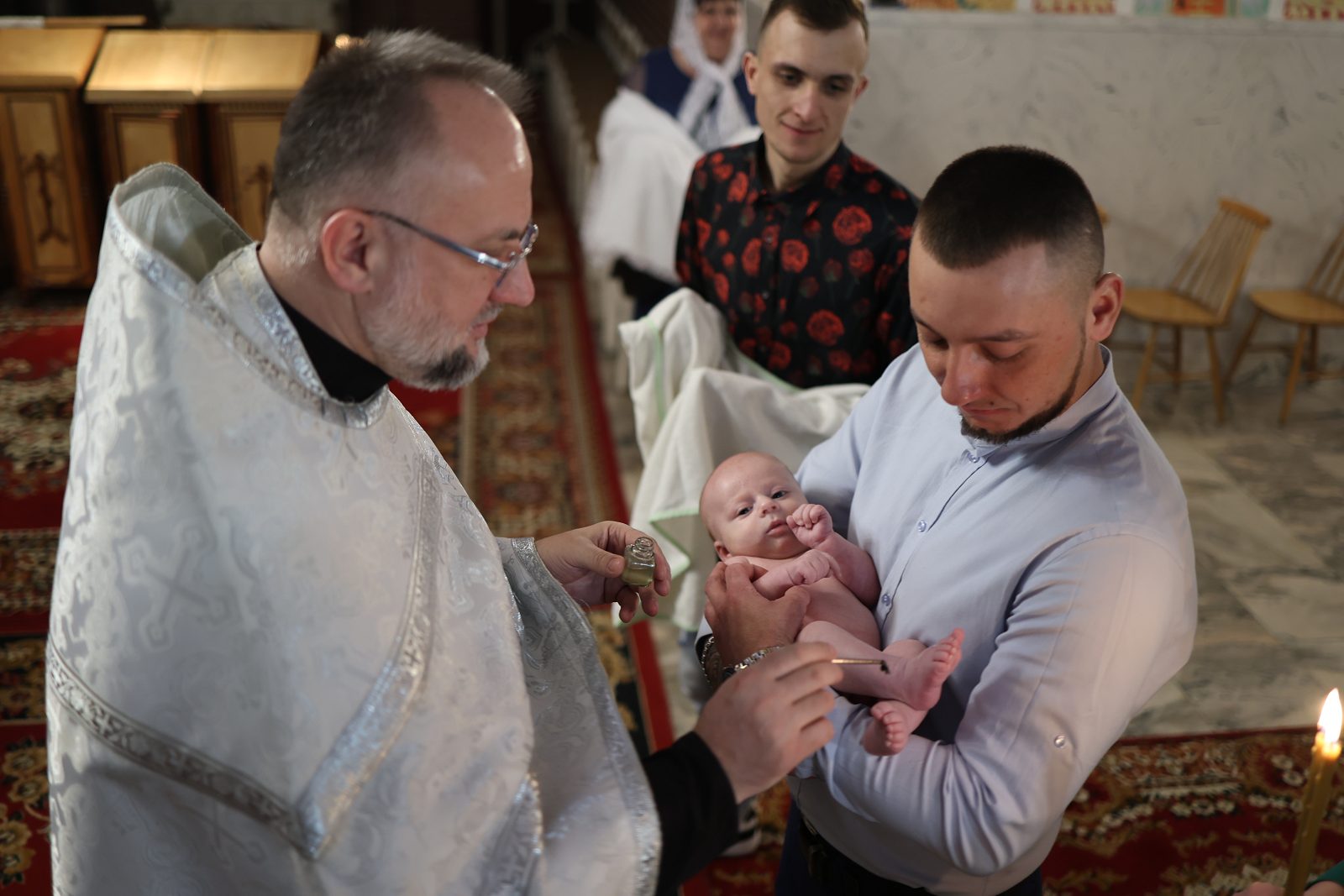 Priest touching an infant during the baptism ceremony