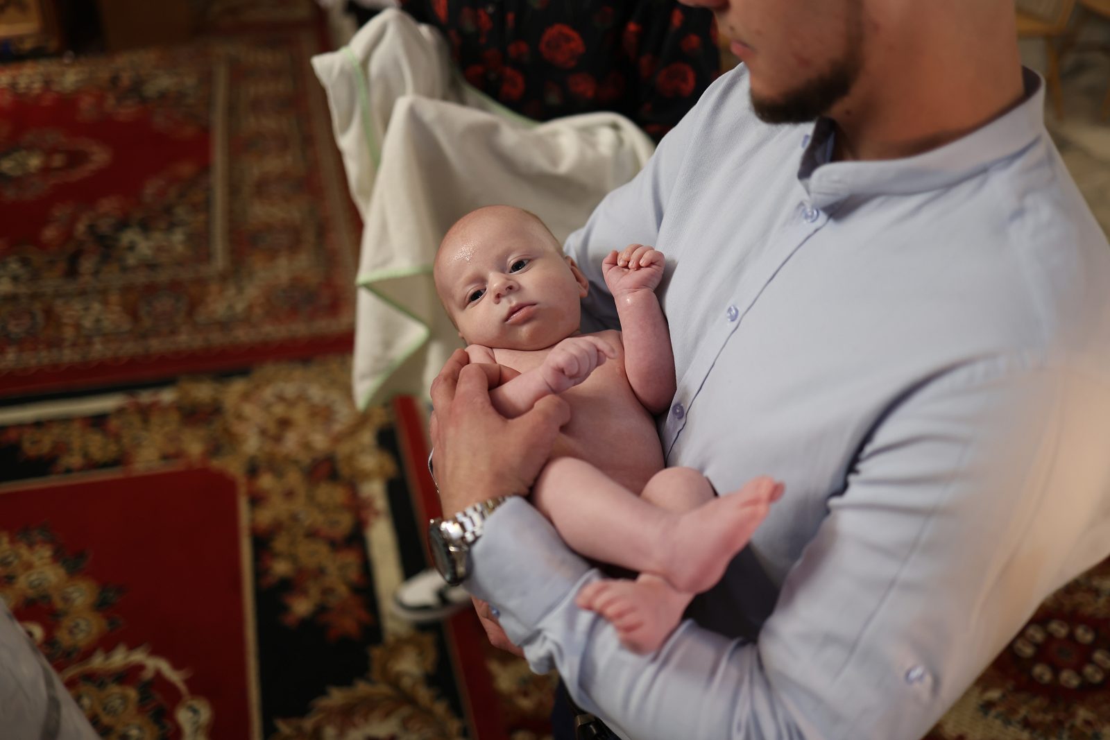 Infant held by a man in church