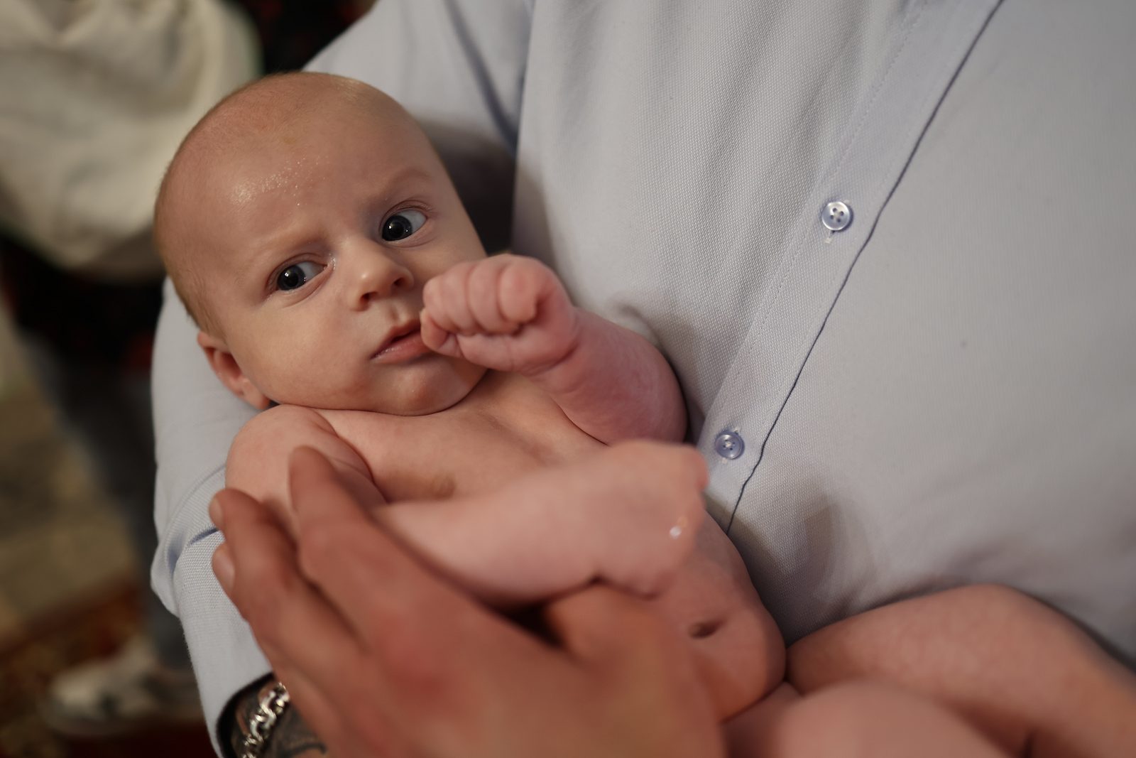 Portrait of an infant held by an adult