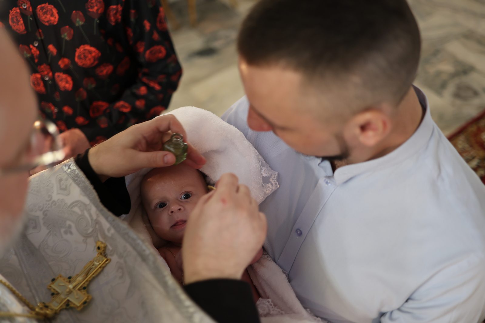 Priest touching an infant’s head during baptism