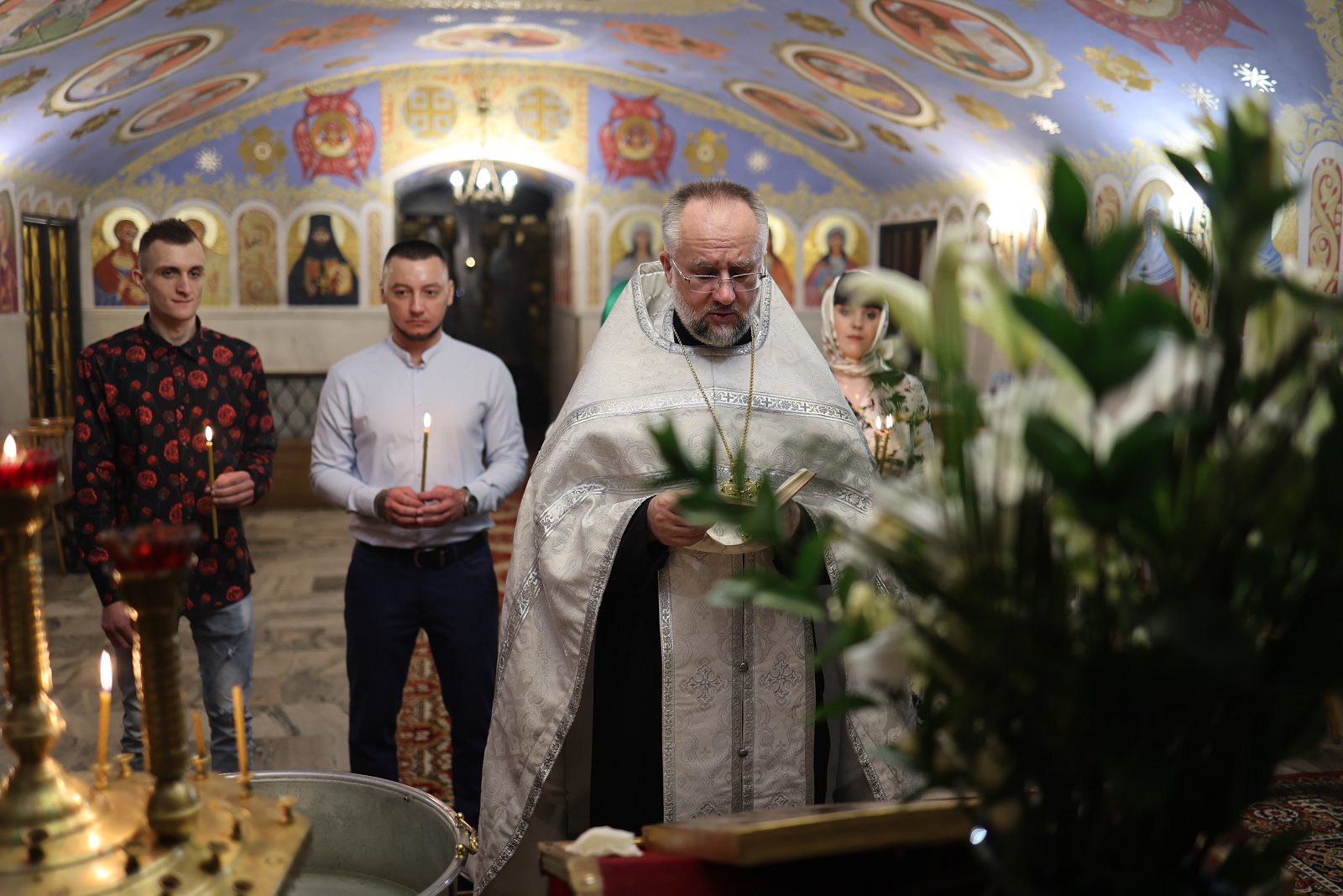 Priest by the baptismal font during the baptism rite