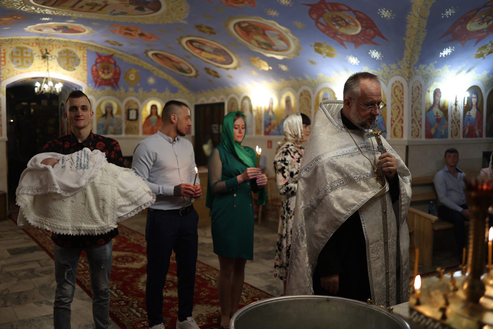 Family and priest in church after the baptism ceremony