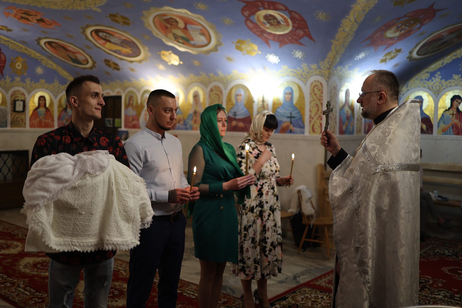 Priest reading a prayer to the family during baptism