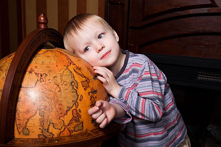 Хлопчик обіймає старовинний глобус