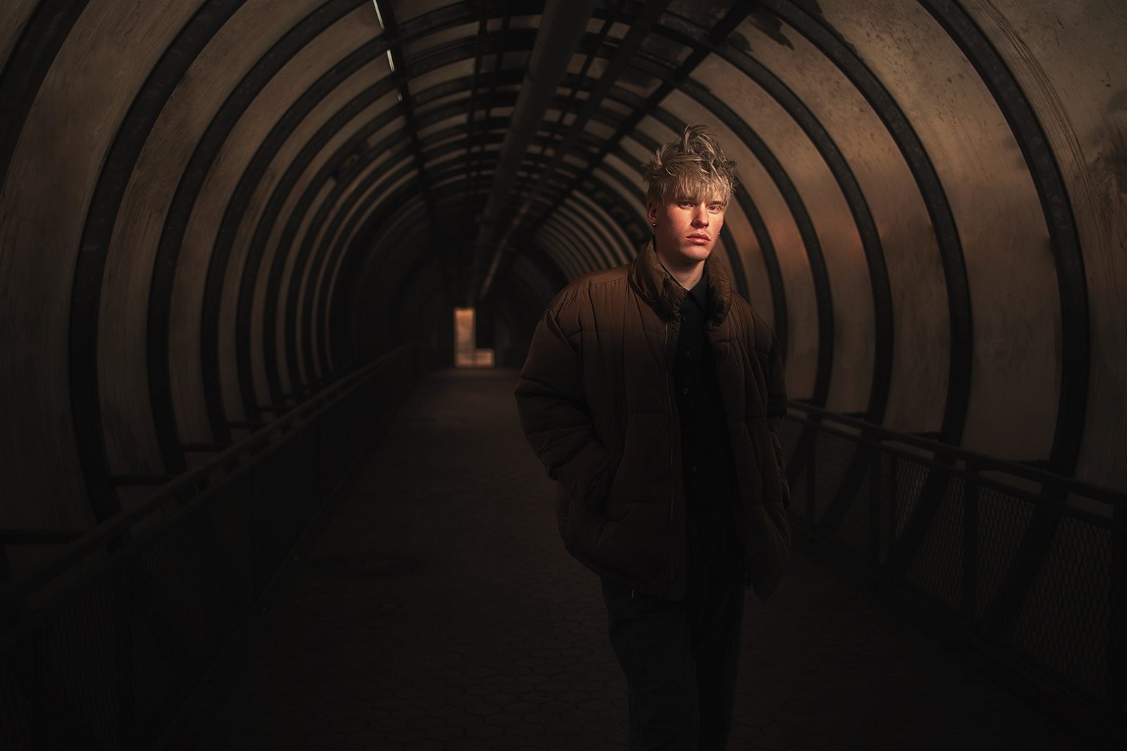 Portret mężczyzny w ciemnej kurtce w tunelu