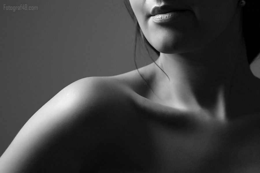 Black-and-white close-up of a woman's shoulder and face