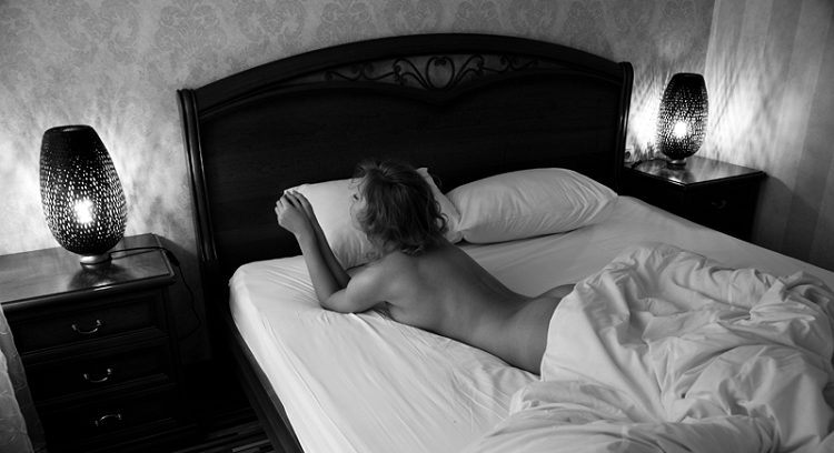 Black-and-white photograph of a woman on a bed