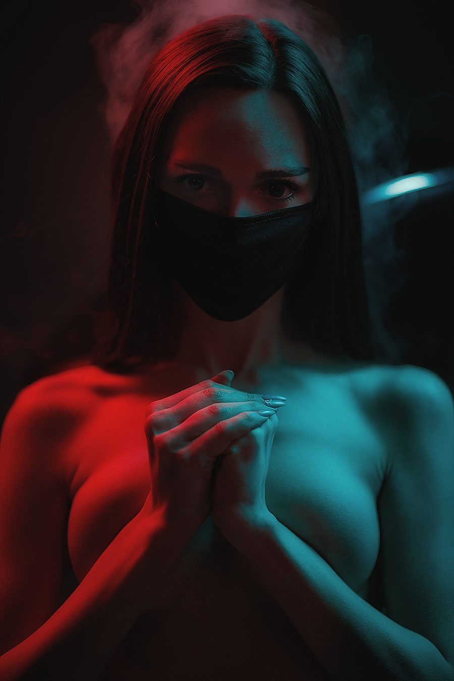 Portrait of a woman in a black mask under red and blue light