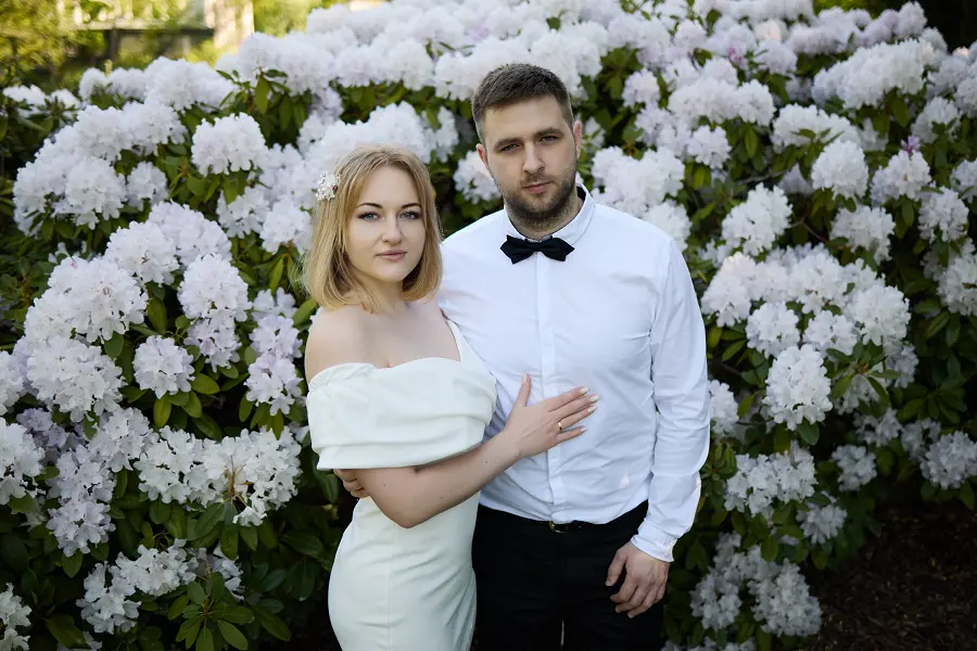 Молодожёны на фоне цветущего куста