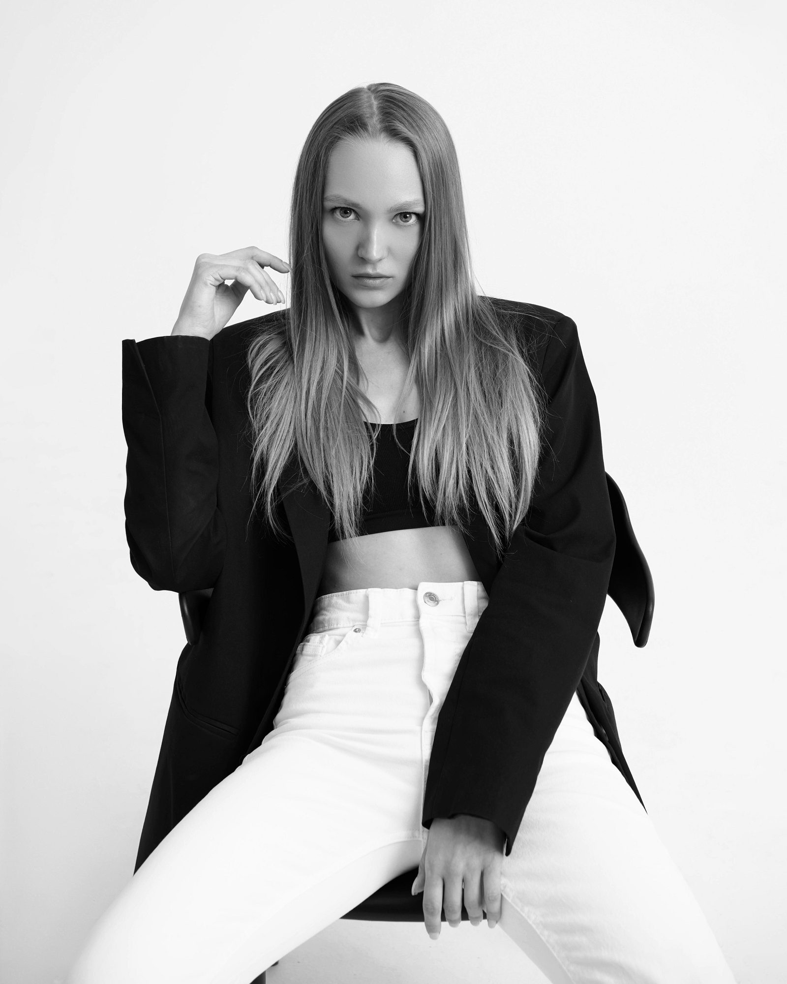 Black-and-white portrait of a woman in a black blazer and white trousers