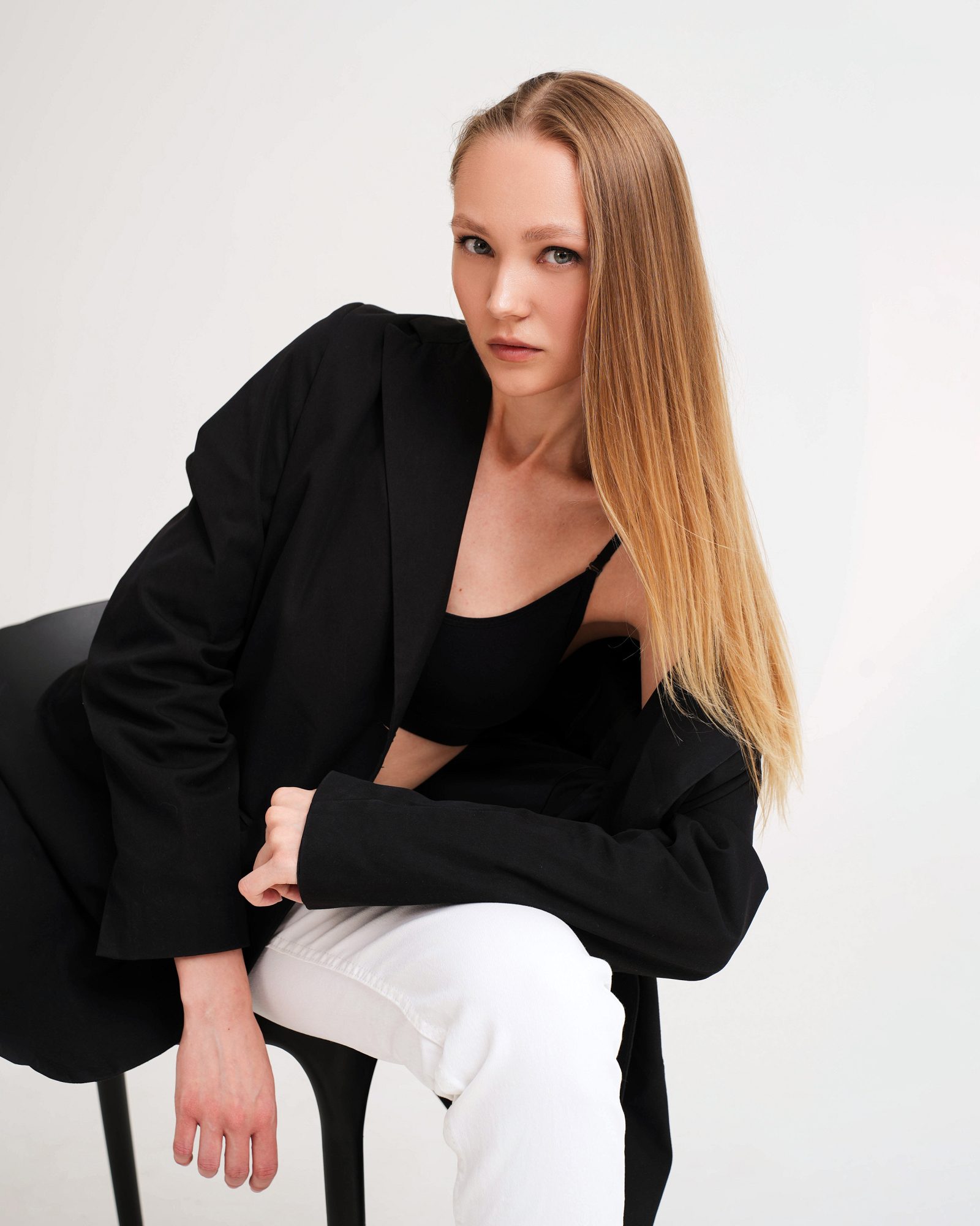 Woman in a black blazer sitting on a chair