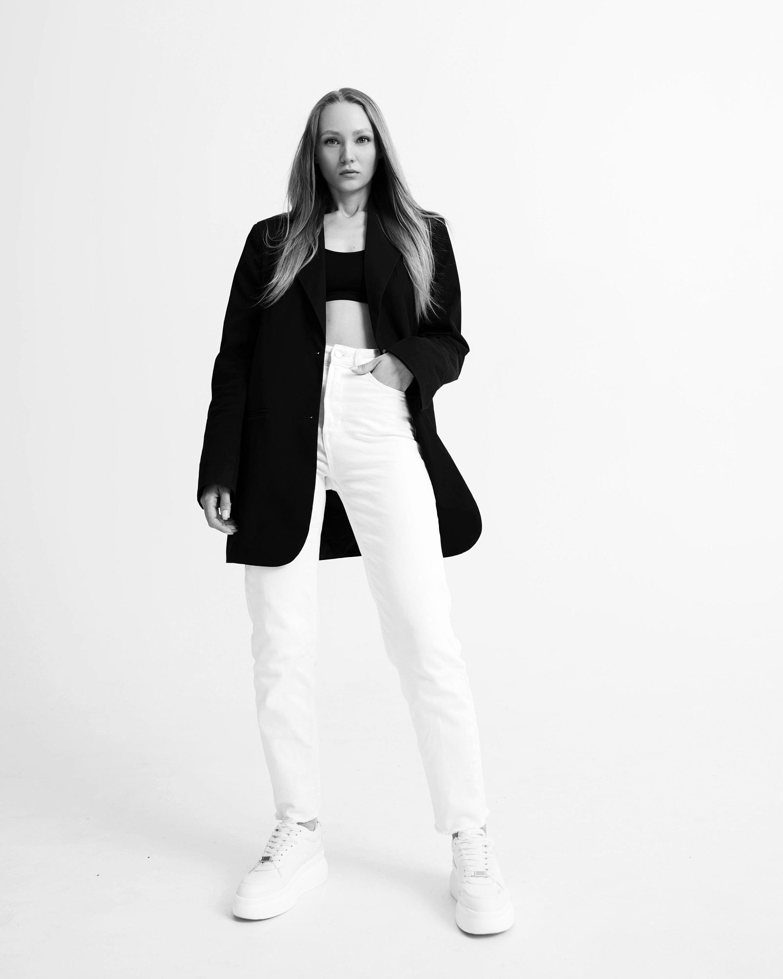 Black-and-white full-length portrait of a woman in a black blazer