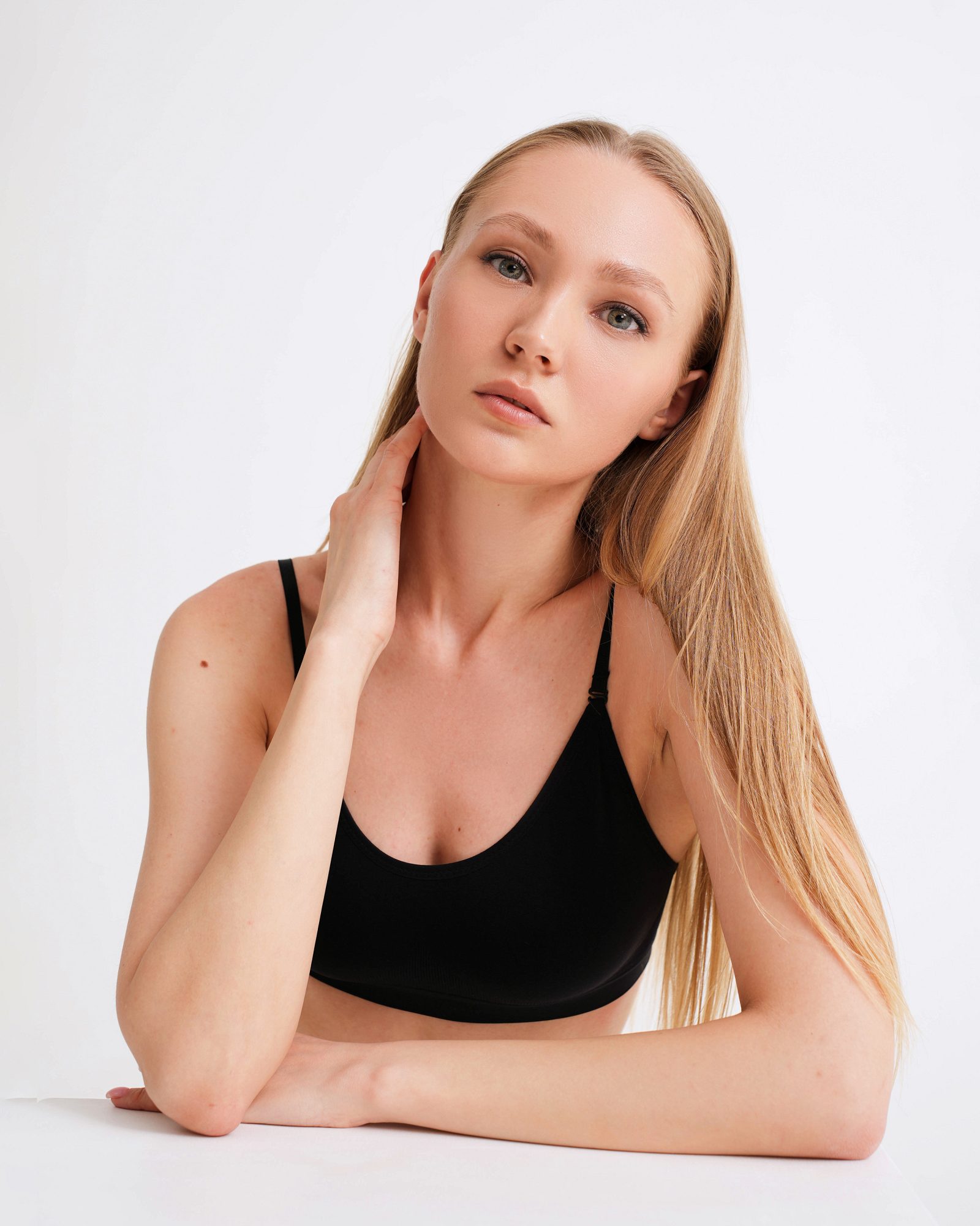 Woman in a black top sitting at a white surface