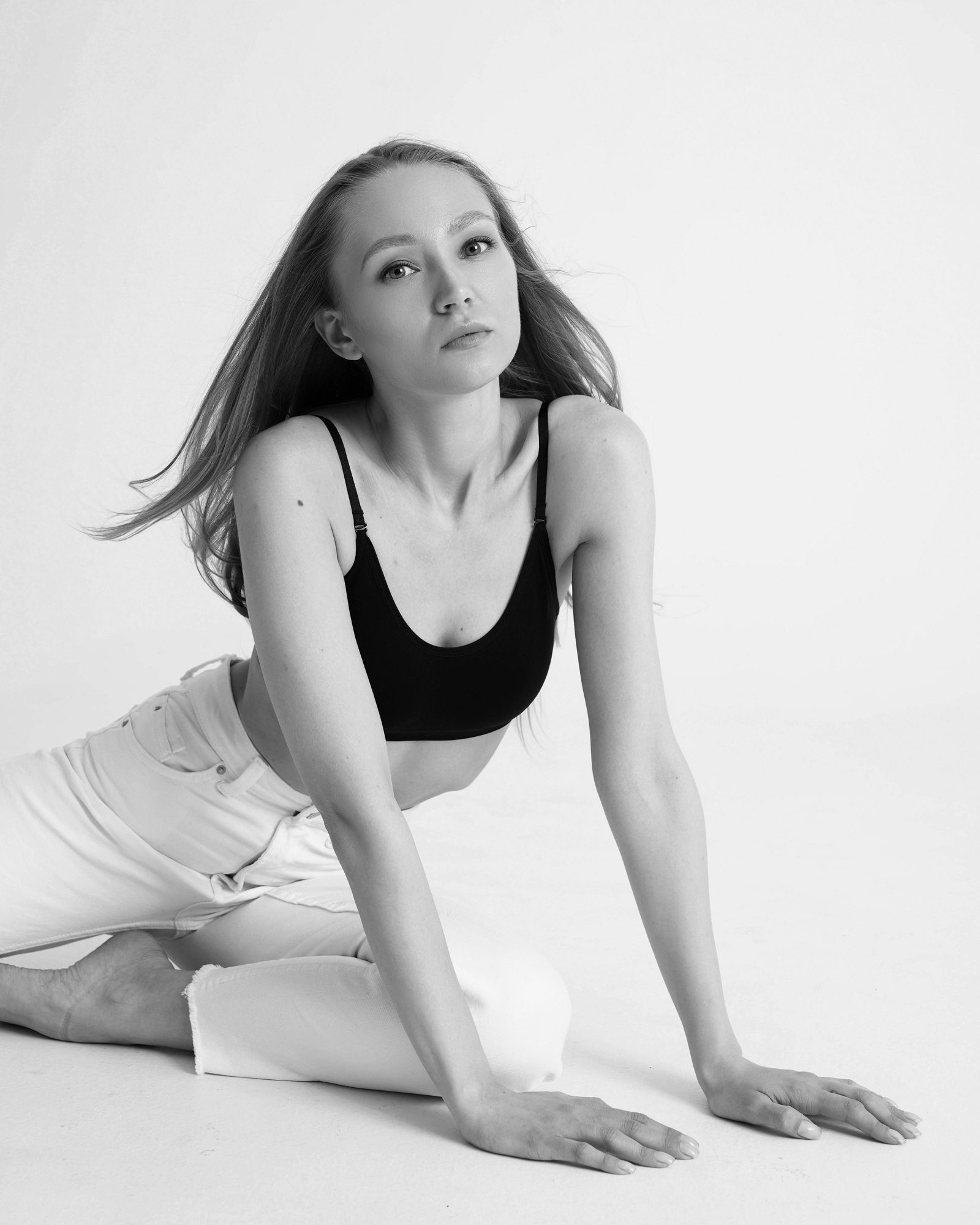 Black-and-white portrait of a woman kneeling on the floor