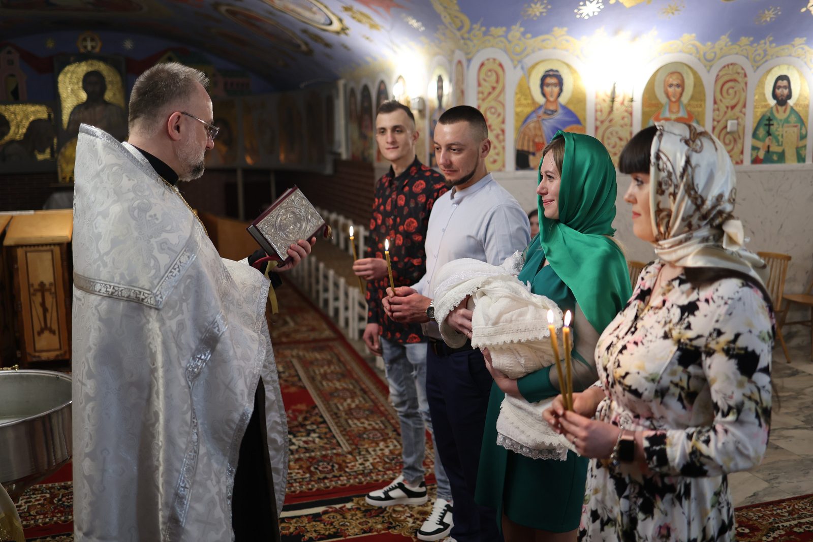 Родина стоїть перед іконостасом під час хрещення