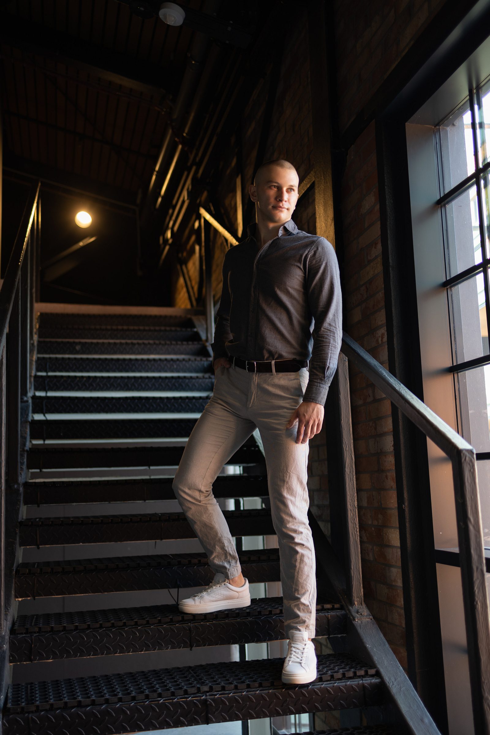Man in a grey shirt on metal stairs