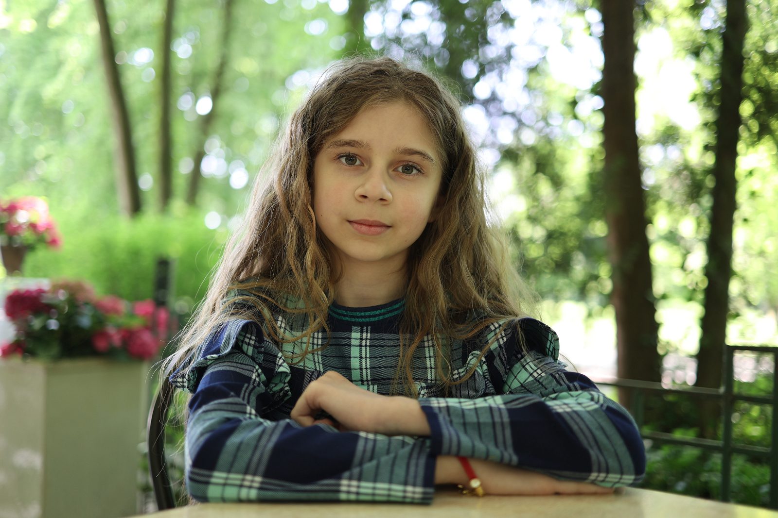Portret dziewczynki w kraciastej sukience na letnim tarasie