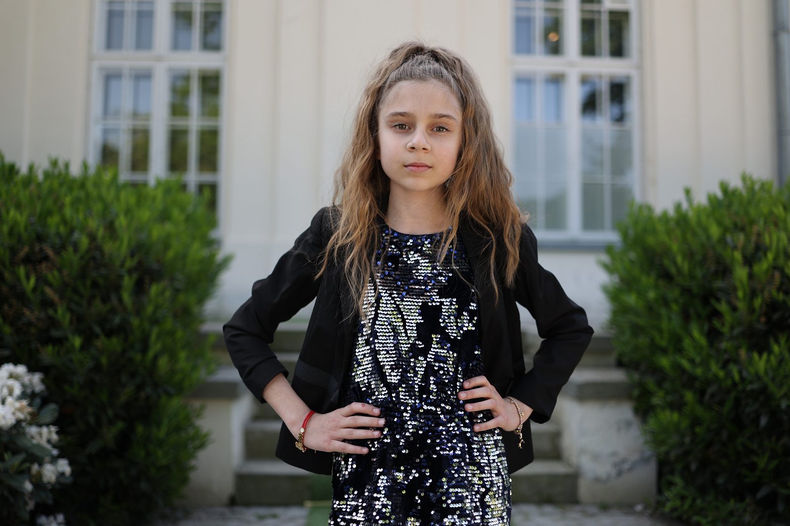 Portret dziewczynki w czarnej sukience przed pałacem