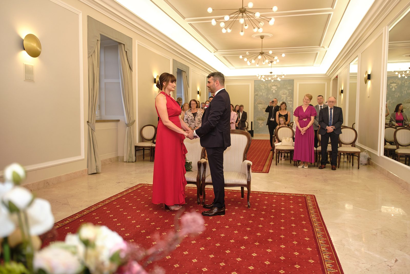 Pan młody i panna młoda uśmiechają się do gości podczas ceremonii.